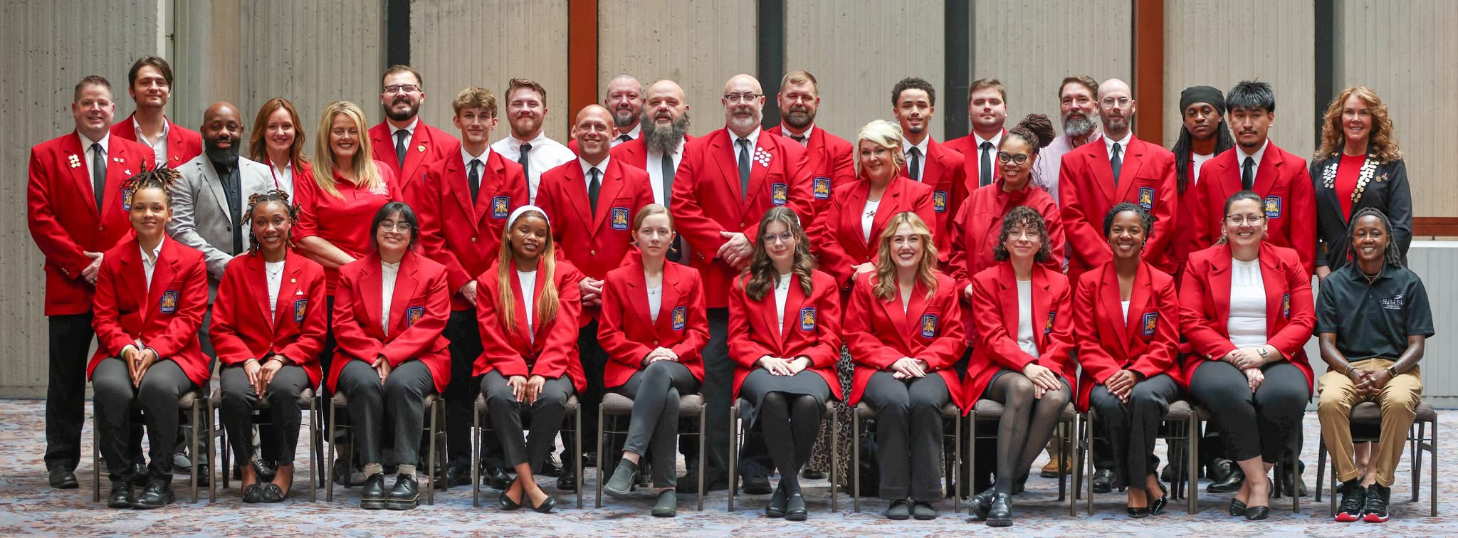 A group of 34 students and advisers in red SkillsUSA jackets stand side by side.