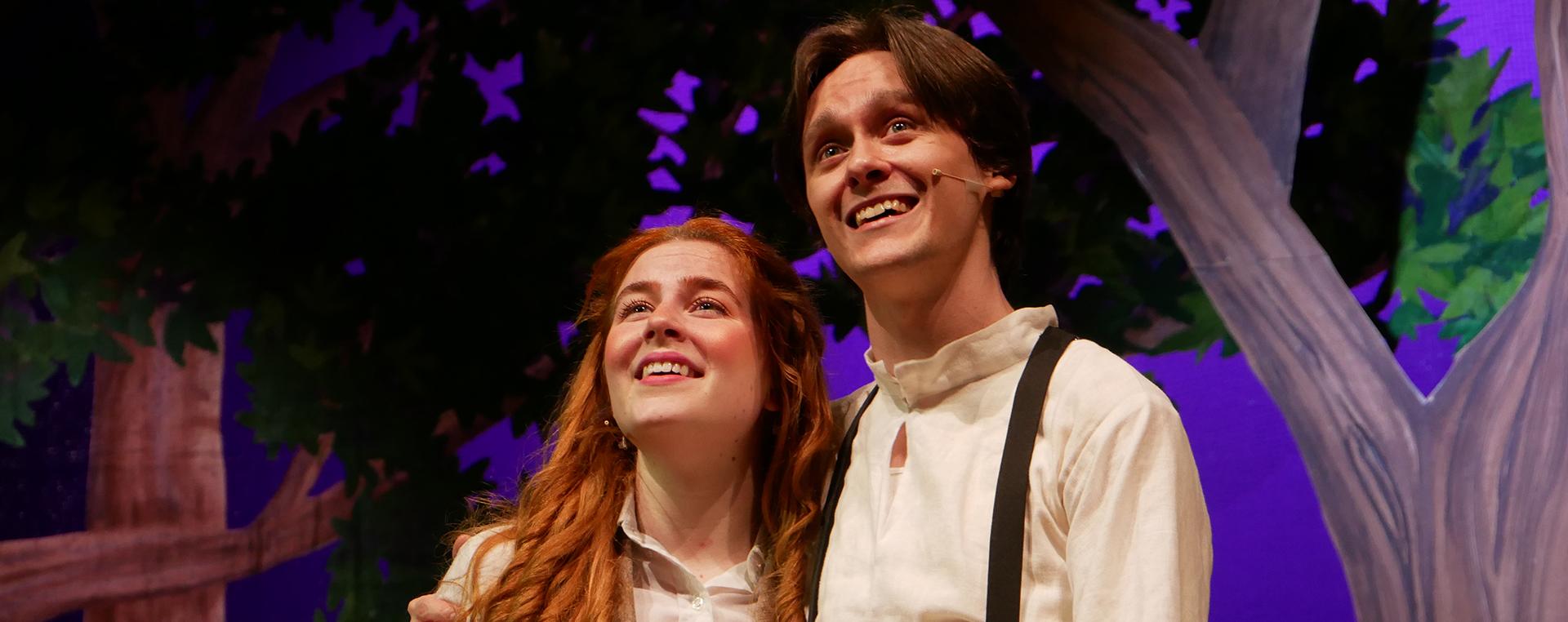 an actor and actress standing on stage