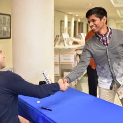 Two students and Global Scholars shake hands