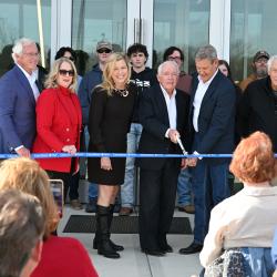 People cutting a ribbon for a new building
