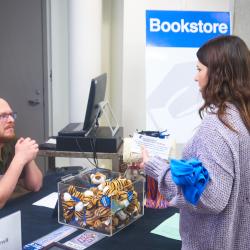 A ChattState student talks to a bookstore worker during the Fall 2023 grad finale.