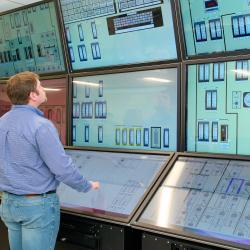 A man looks at a simulated nuclear control room.