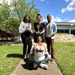 Tashona M., Carolina S., and Niel H. stand outside the OMNI building holding trophies.