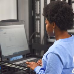 A woman in a blue shirt types on a computer. A woman in a blue shirt types on a computer.