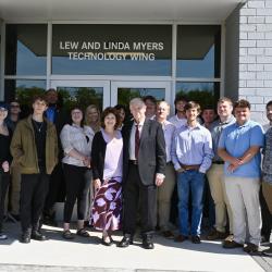 Lew and Linda Myers, center, stand surrounded by ChattState students and faculty under a sign that reads "Lew and Linda Myers Technology Wing."