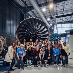 ChattState students and instructors stand before a jet engine while visiting the Rolls-Royce facility in England.
