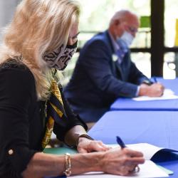 woman and man at table signing agreement