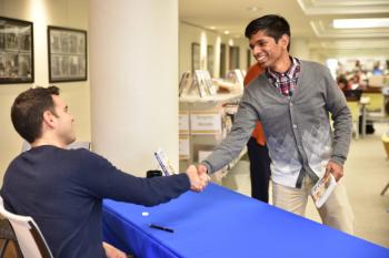Two students and Global Scholars shake hands