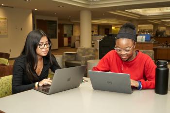 Two students look at their computers in ChattState's library.