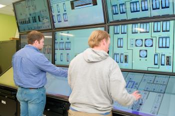 Nuclear Recognition Two male students interract with an educational digital nuclear control room display.