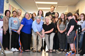 A group of students, faculty, and staff gather in a hallway at ChattState