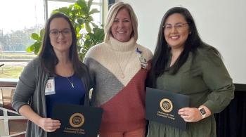 3 women two are holding certificates