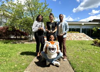 Tashona M., Carolina S., and Niel H. stand outside the OMNI building holding trophies. Tashona M., Carolina S., and Niel H. stand outside the OMNI building holding trophies.