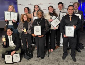 10 ChattState students in formal clothing hold ADDY awards in front of an American Advertising Federation backdrop.