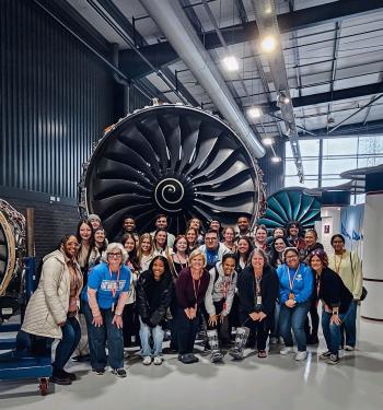 ChattState students and instructors stand before a jet engine while visiting the Rolls-Royce facility in England.