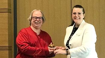 a woman passing gavel to a man