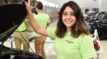 student with hand on car hood
