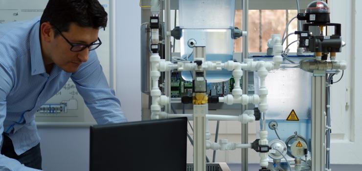 man wearing glasses looking at laptop in lab