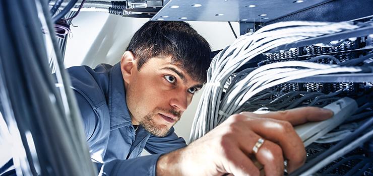 network specialist uses an insertion tool to snap wires into place